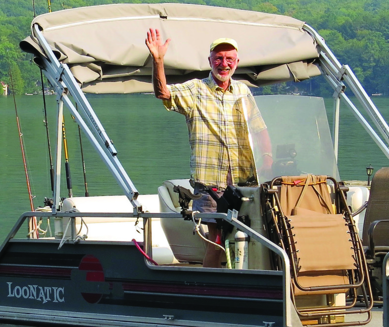 Loon volunteer Mike Korkuc enjoys a sunny day on his boat, “Loonatic.” / © Rosie Spahn 