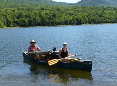 Eric Hanson and Grace Mitchum paddle with the raft balanced on the canoe. Photo by Amber Wolf.