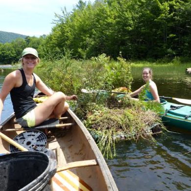 Grace Mitchum and Amber Wolf moving a newly vegetated raft on Chittenden Reservoir. Photo by Eric Hanson.